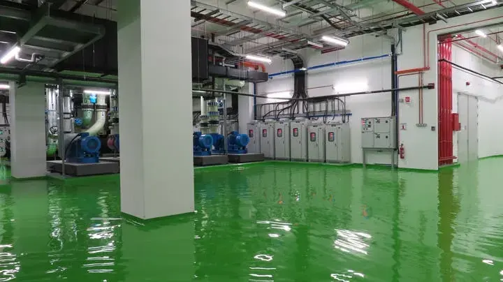Standing water across the floor of a large building mechanical room