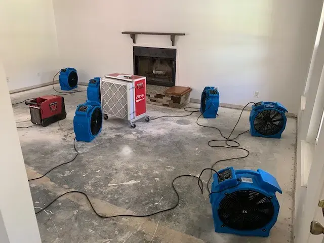 Air movers, a dehumidifier and an air scrubber drying a room down to the subfloor